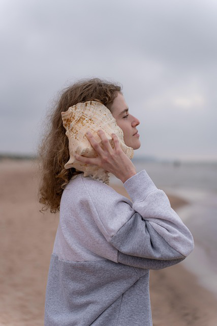 contatto telefonico lido cala dei longobardi termoli Ragazza con una conchiglia all’orecchio sulla spiaggia di Termoli, simbolo del contatto diretto con il lido.